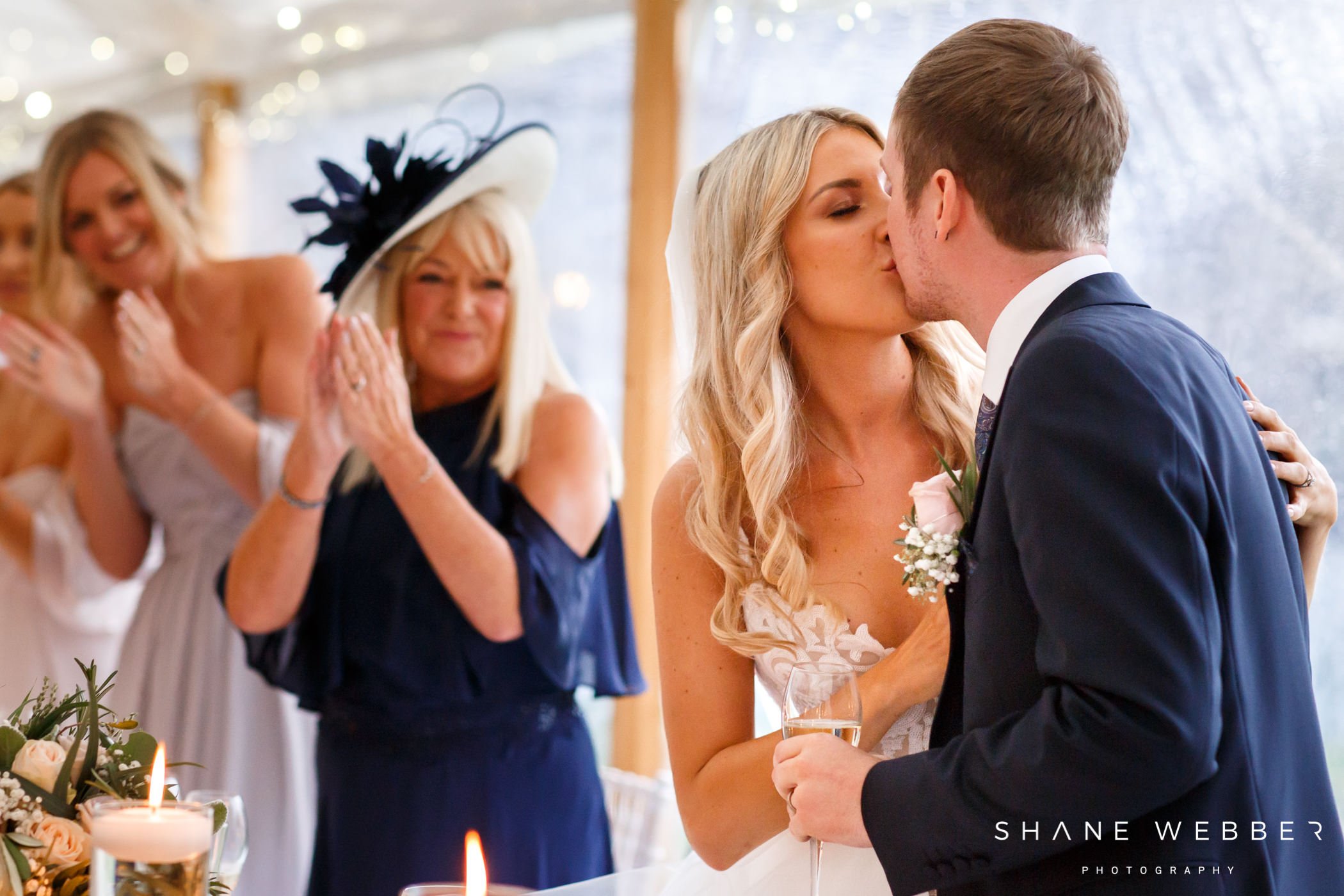 bride and groom kiss during the speeches
