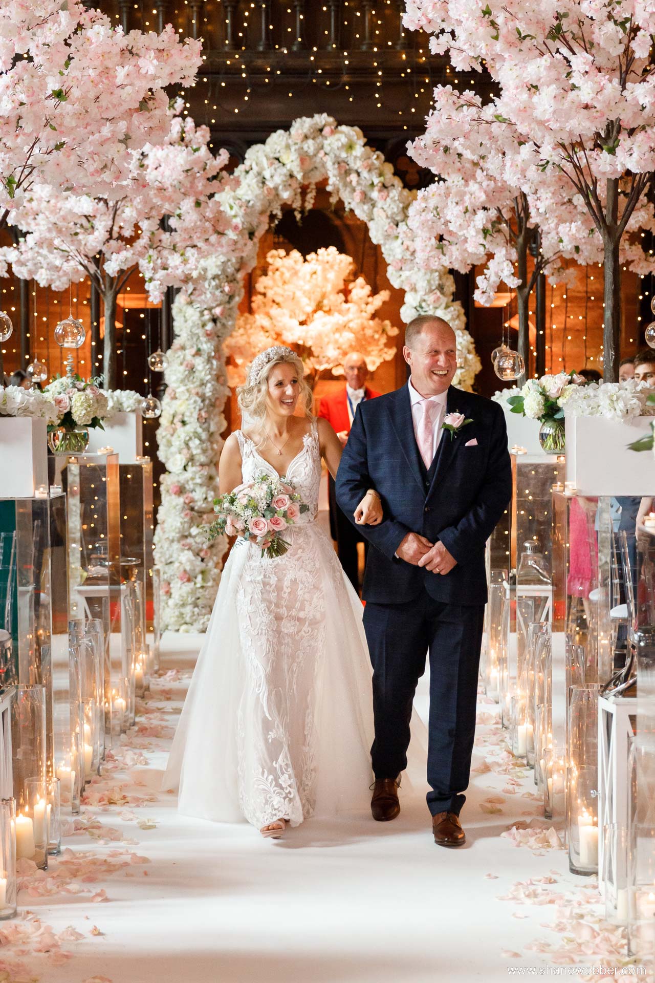 Luxury weddings at Peckforton Castle with pink blossom trees